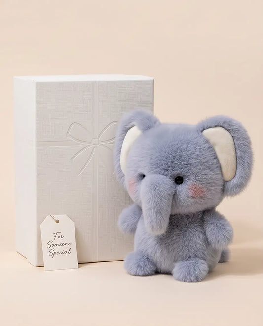 Giggle Bubs fluffy comforter for toddlers, a soft plush elephant beside a gift box.
