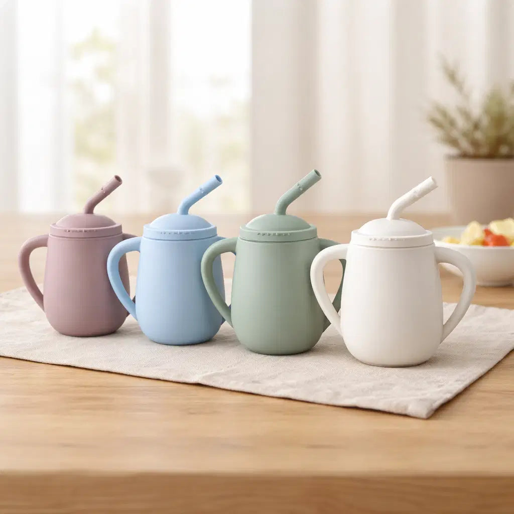 Various colors of Giggle Bubs toddler silicone straw cup on a table, showcasing the EasySip design for toddlers.