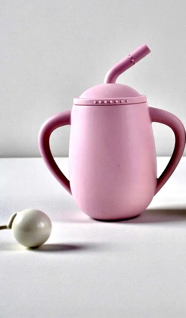 Giggle Bubs EasySip toddler silicone straw cup in pink with ergonomic handles and straw, designed for toddlers learning to sip.