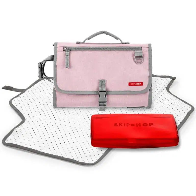Skip Hop pink portable changing station with polka dot changing pad and red wipes case.